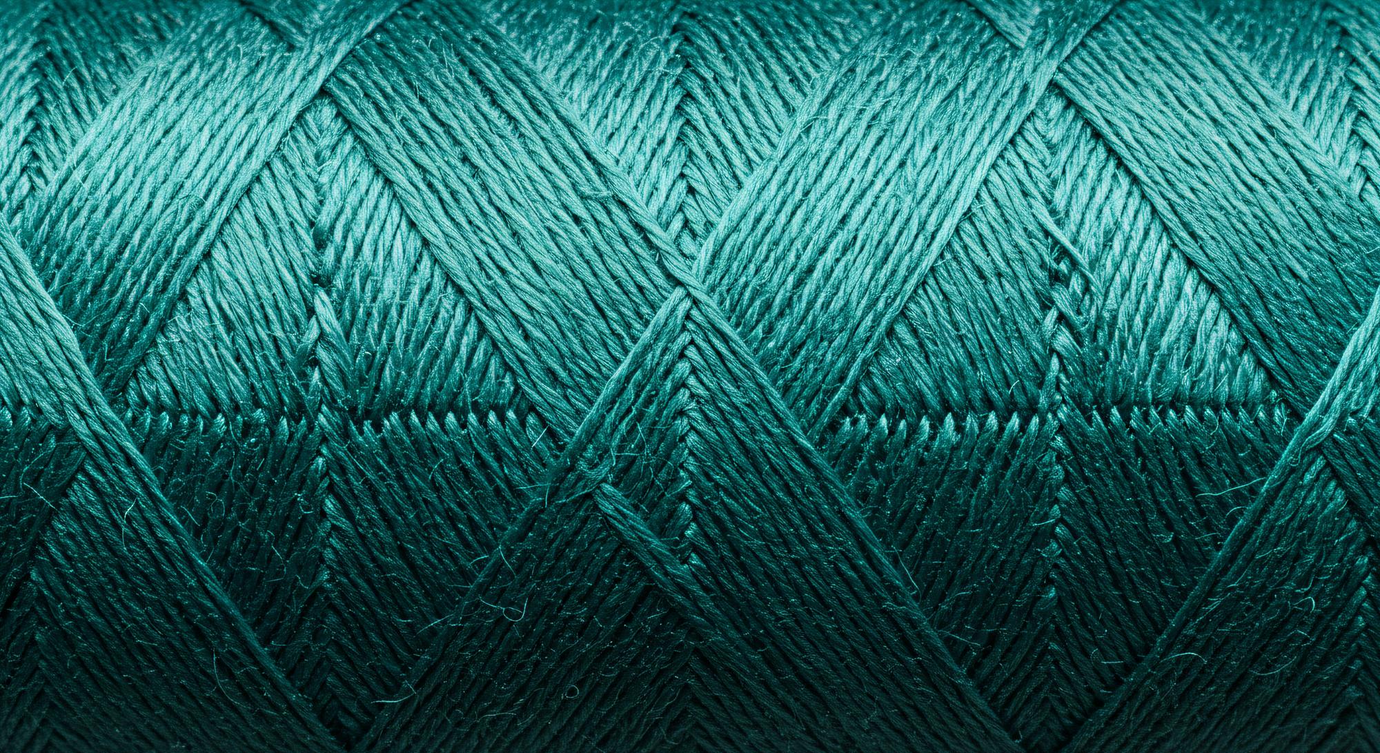 Close-up of thread texture in teal and gold